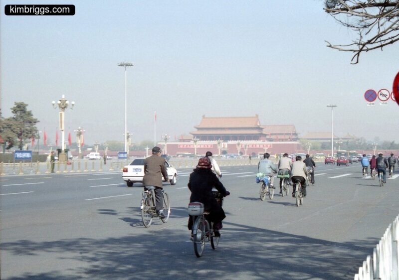 Poeple riding bicycles in Tiananmen Square.