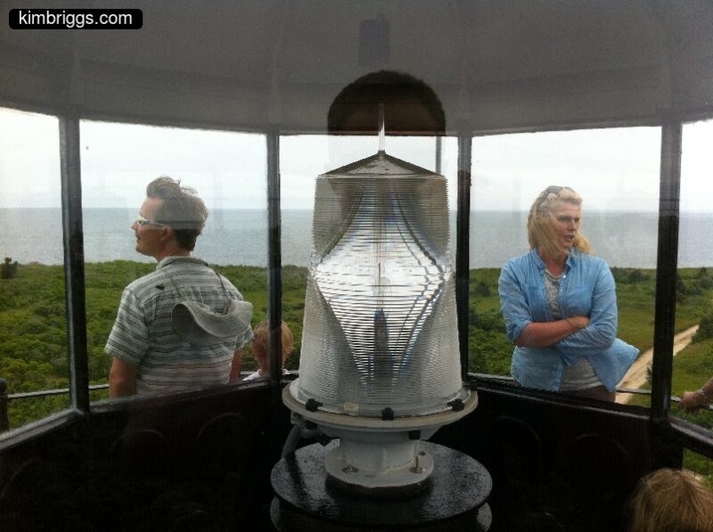 2 people next to lighthouse bulb