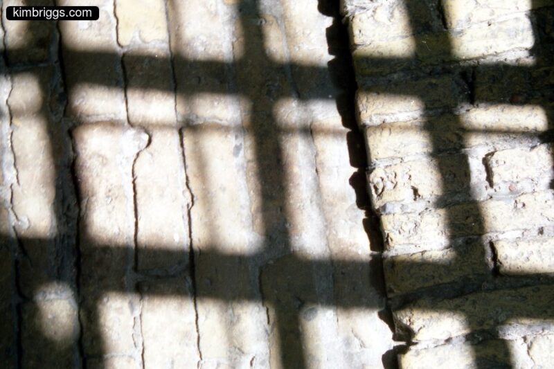 Artistic shadows on cobblestone floor.