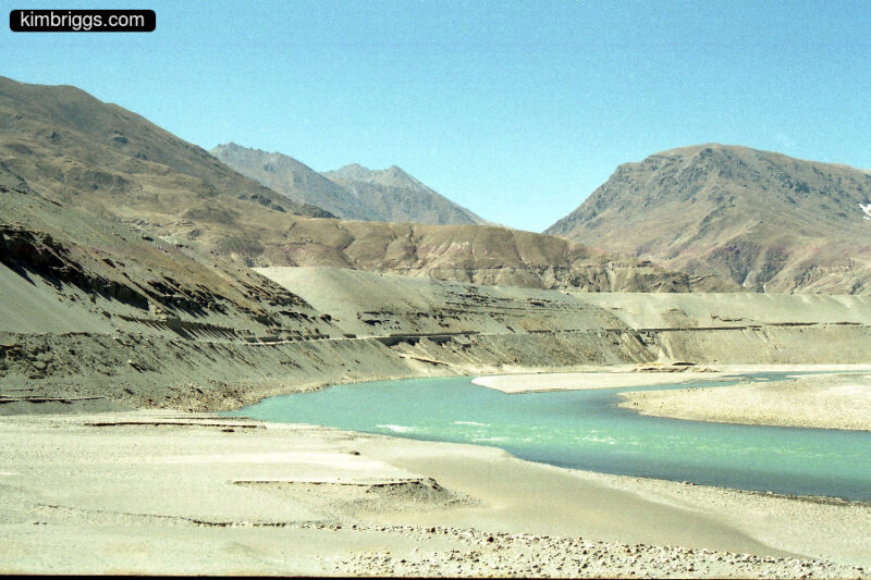 Tibet desert mountains with aqua-colored river.