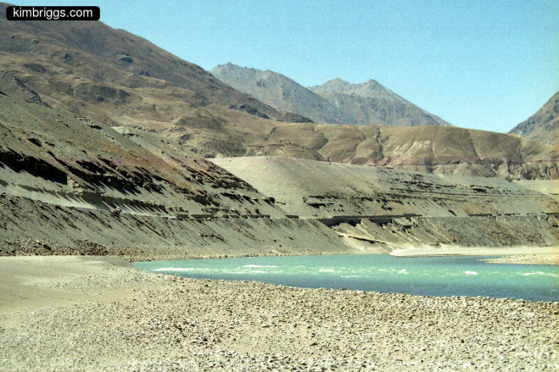 Sandy Tibetan mountains and rocky river bed.