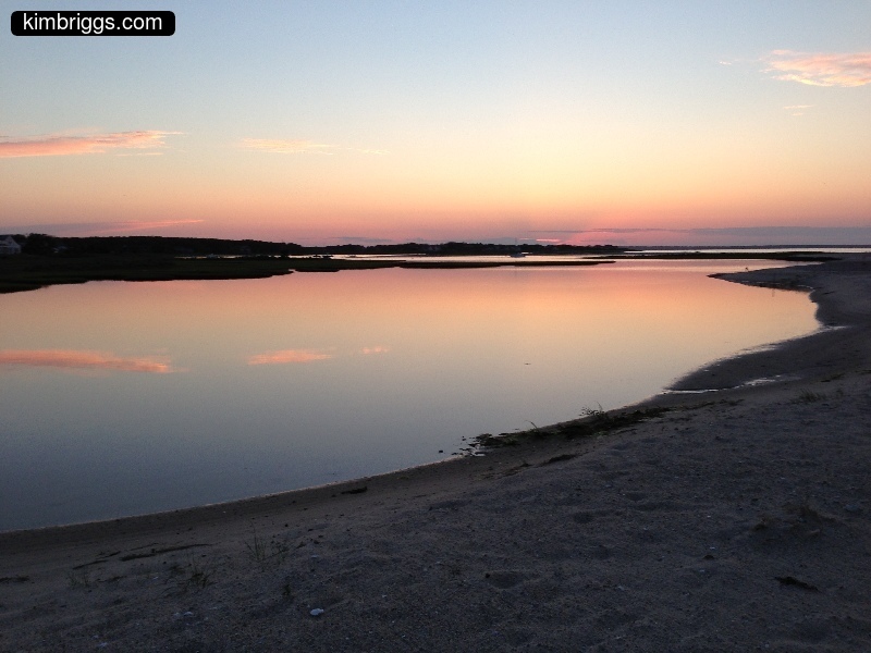 Colorful first-light sunrise over water.