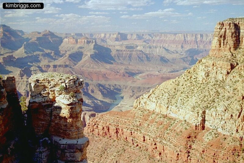 Colored canyon walls with river in distance.