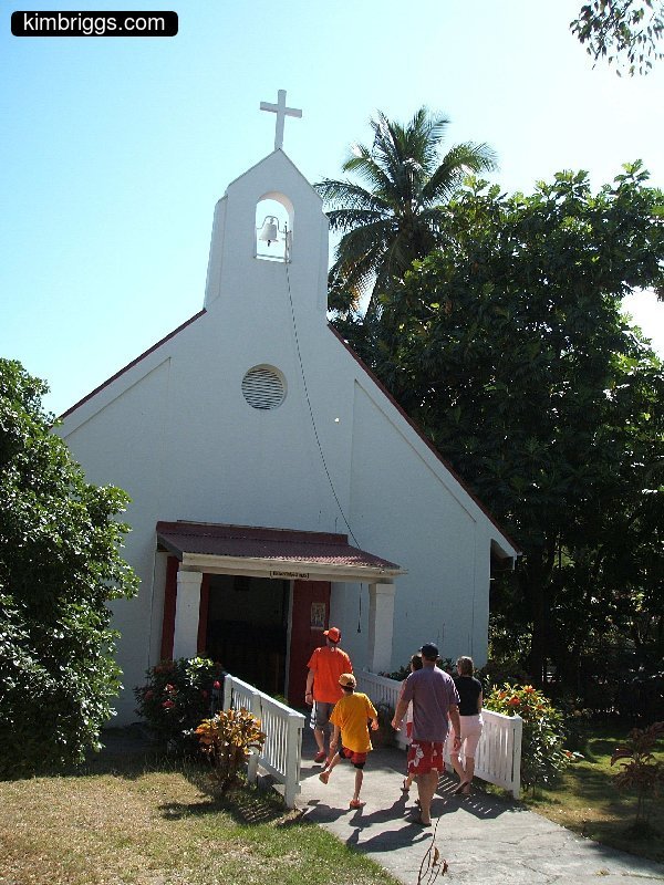 Small church with casual visitors entering.