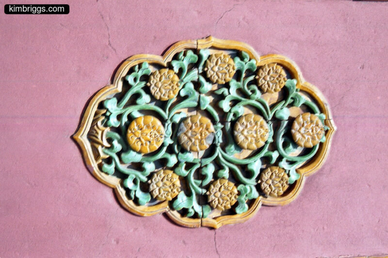 Detail of decoration on wall. Yellow and green on red.
