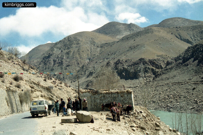 People at small road stop near river in rural TIbet.