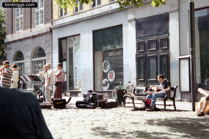 Street musicians in cobblestone area.