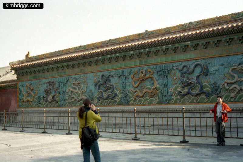 Tourists in front of dragon wall in Forbidden City.