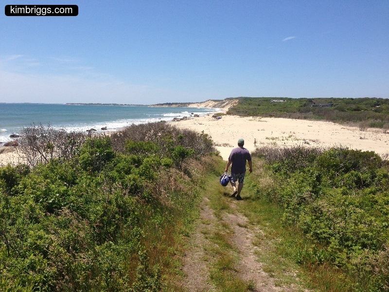 Man walking on path to beach.
