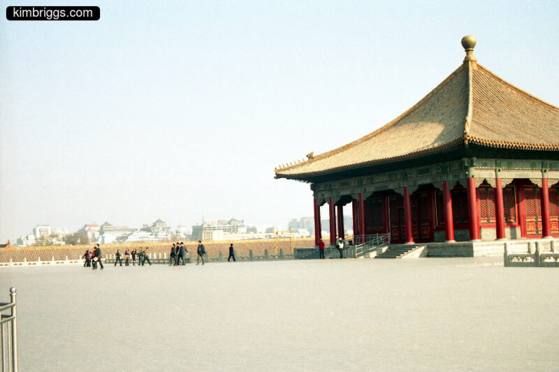 Chinese building with curved roof and Beijing skyline.
