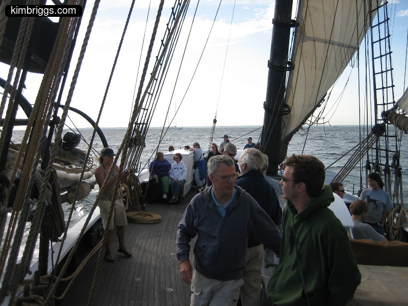 People standing on large sailboat tour.