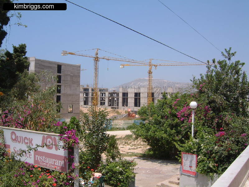 Construction cranes and cement walls.