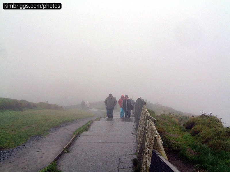 People on a stone walk in the fog.