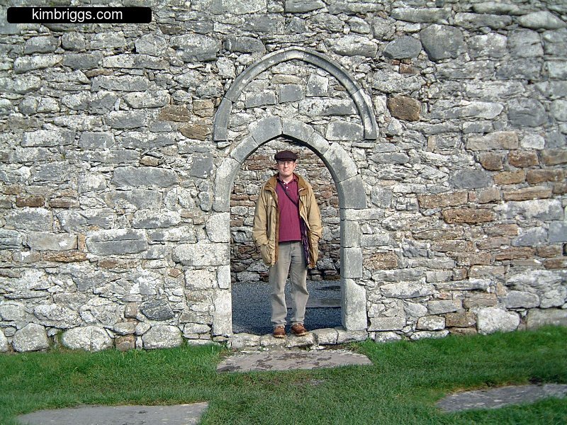 Man standing in stone arch.