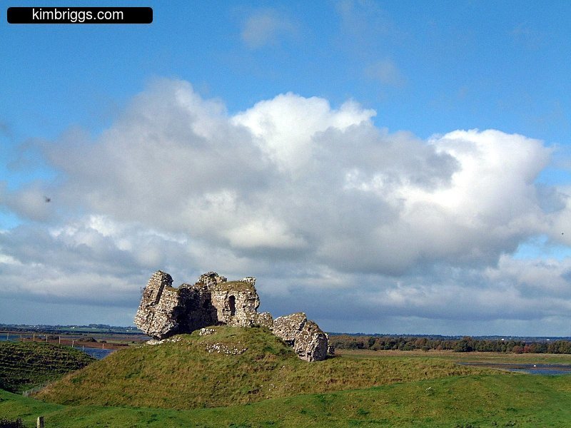 Stone ruins at top of green hill.
