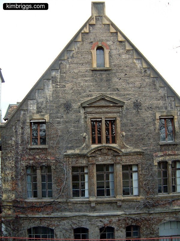 Stone building with decorative windows.