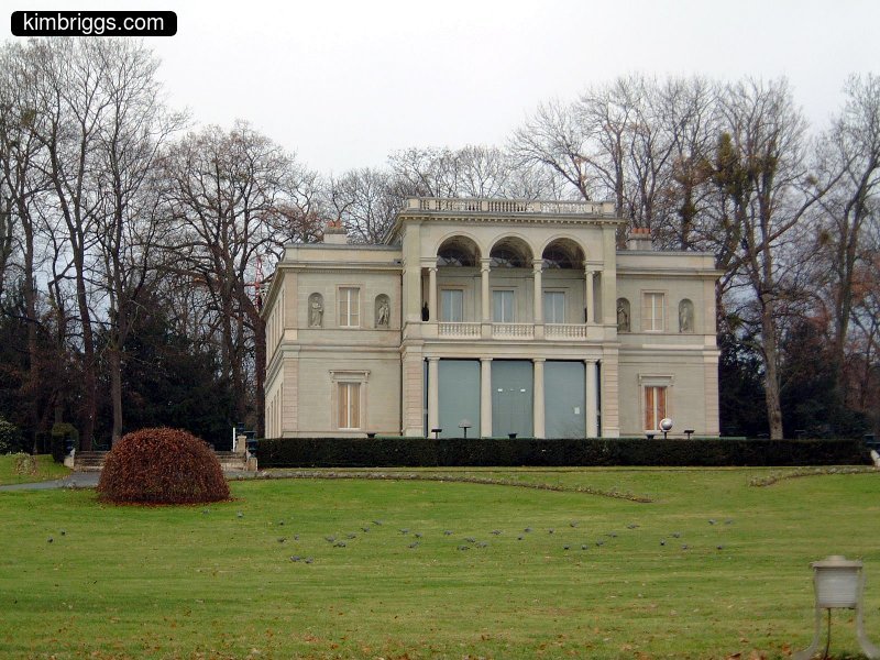 Large white stone building on a green lawn.