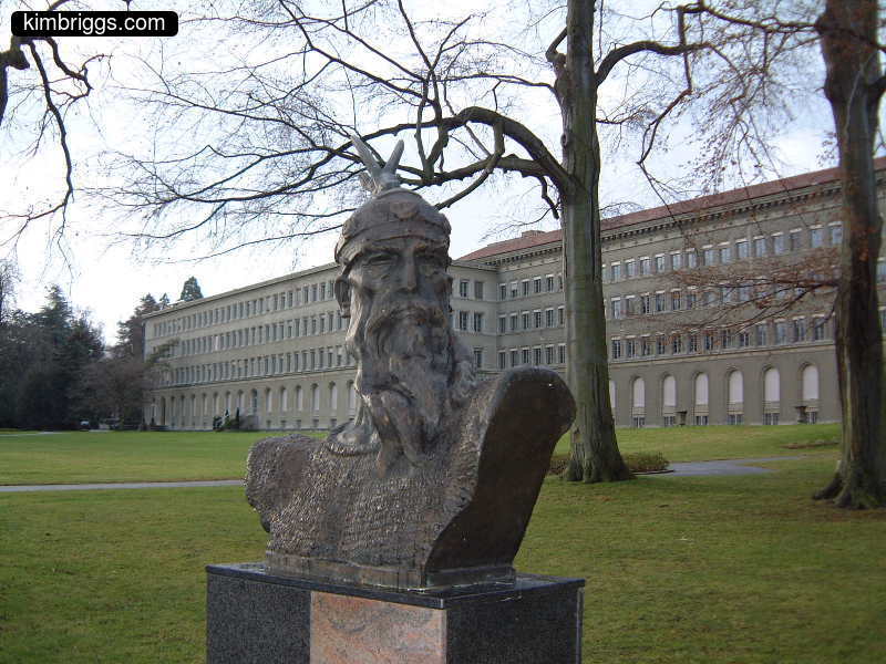 Bust of a bearded man on a green lawn.