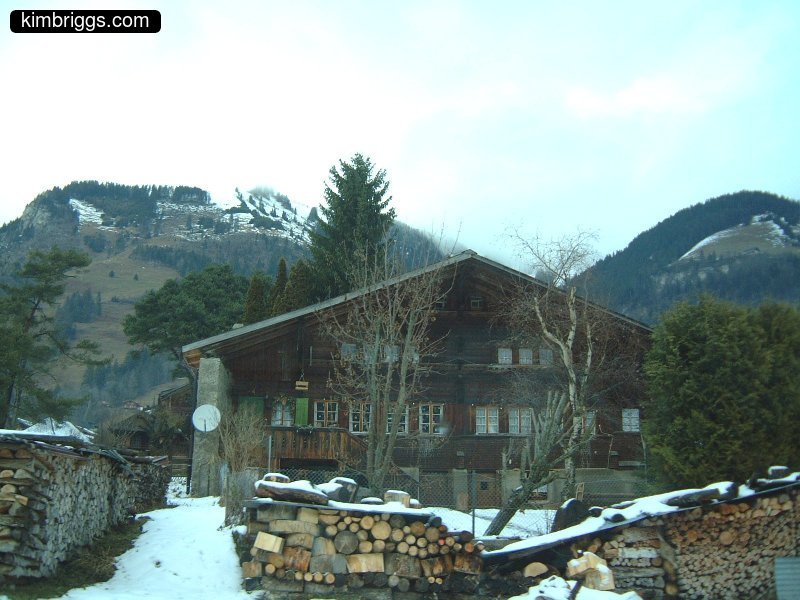 Wooden Swiss house with huge stacks of firewood.