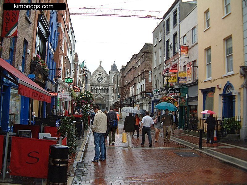 Rainy street in Dublin with pedestrians.