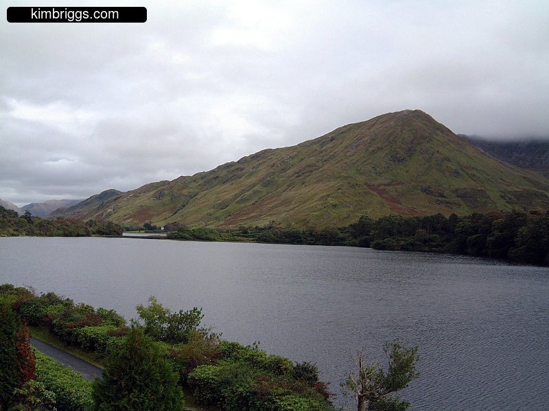 Large lake near green hill in Ireland.