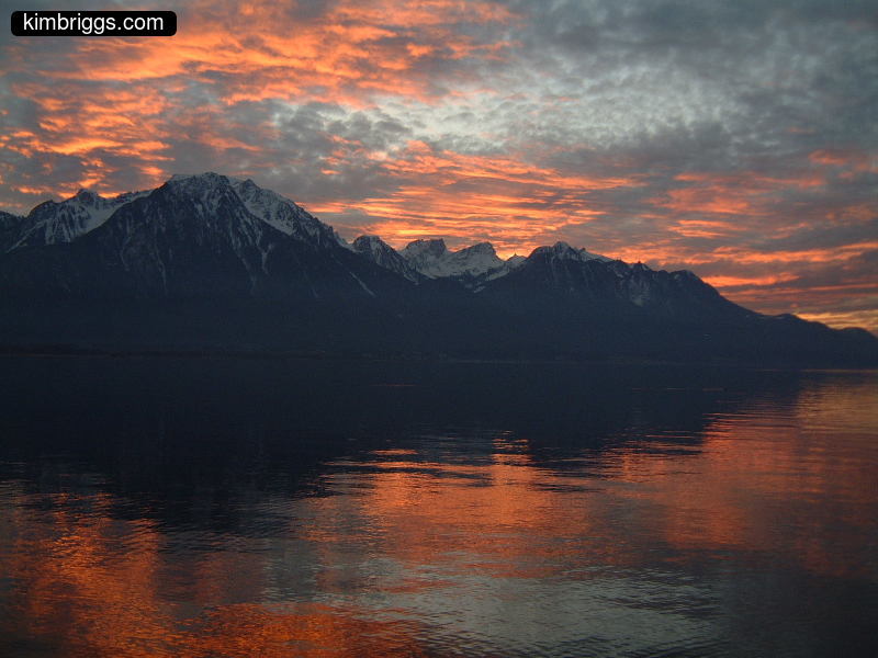 Colorful sunset over lake and mountains.