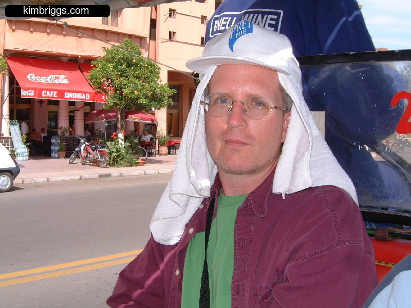 Man with hat and towel on head to protect from sun.