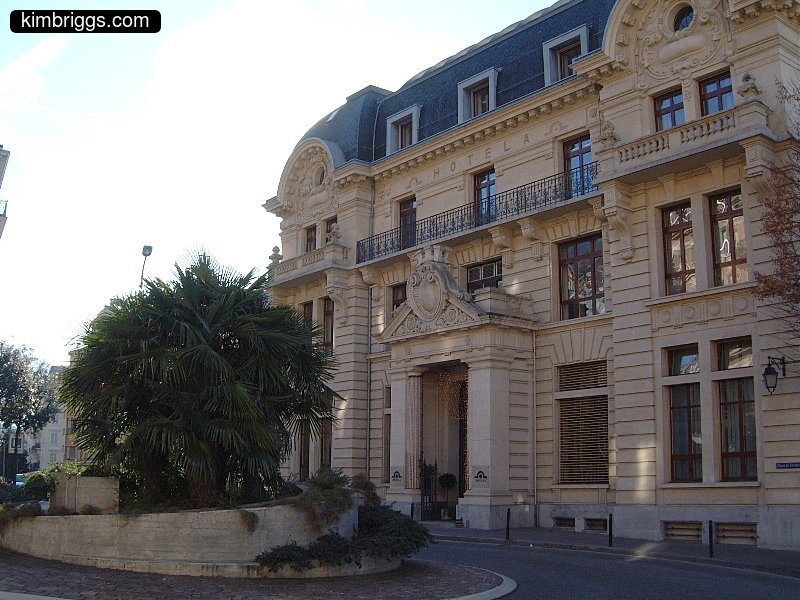 White stone building with black roof.