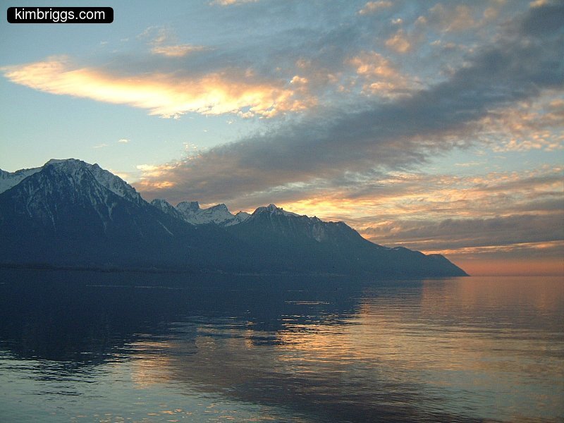 Sunset starting over mountains and lake.