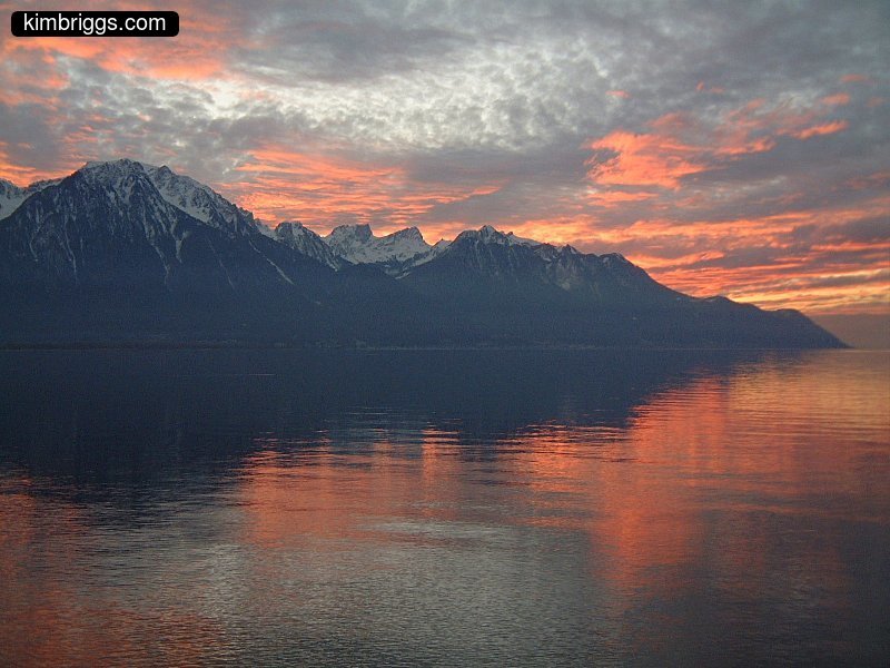 Very colorful sunset over lake and mountains.