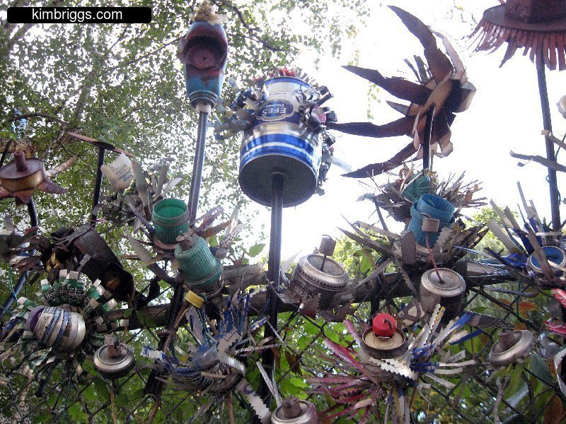 Art made from cans and found objects on a fence.