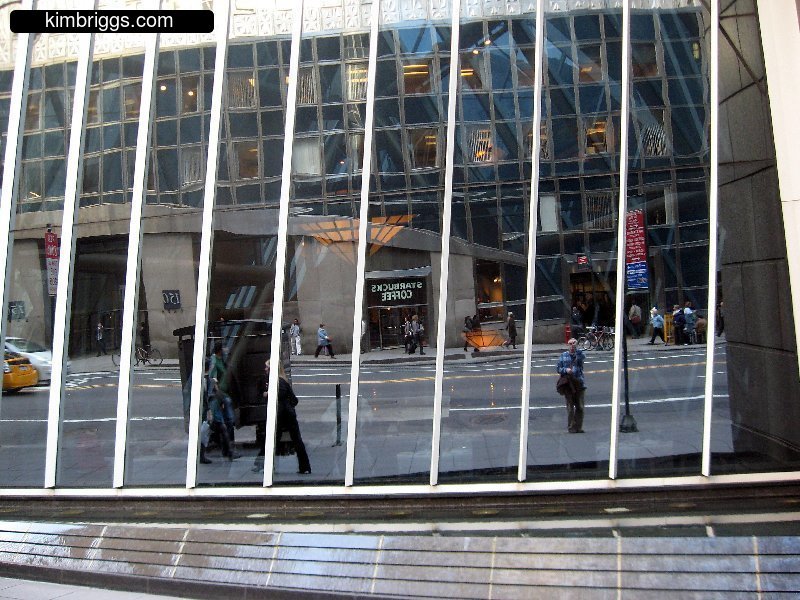 View of New York City street from glass building reflection.