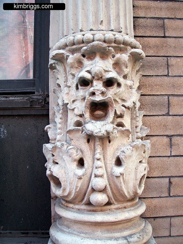 Creepy faces sculptures on old-style pillar.