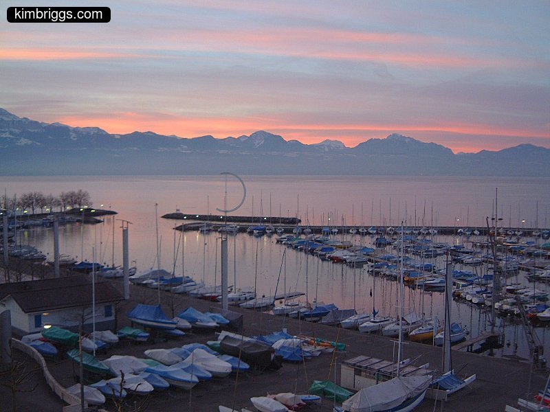 Colorful sunset over marina and mountains.