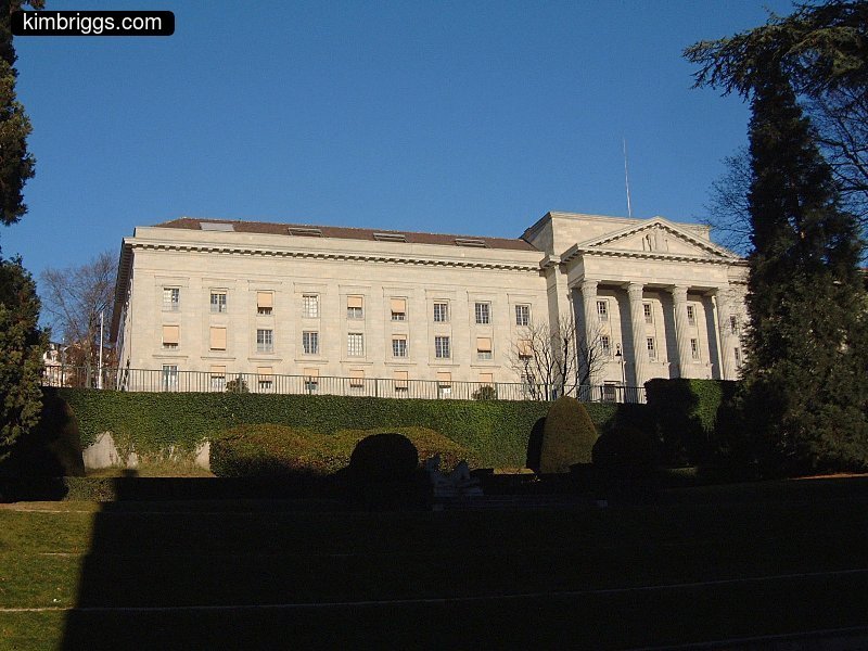 White stone building with pillars in front.