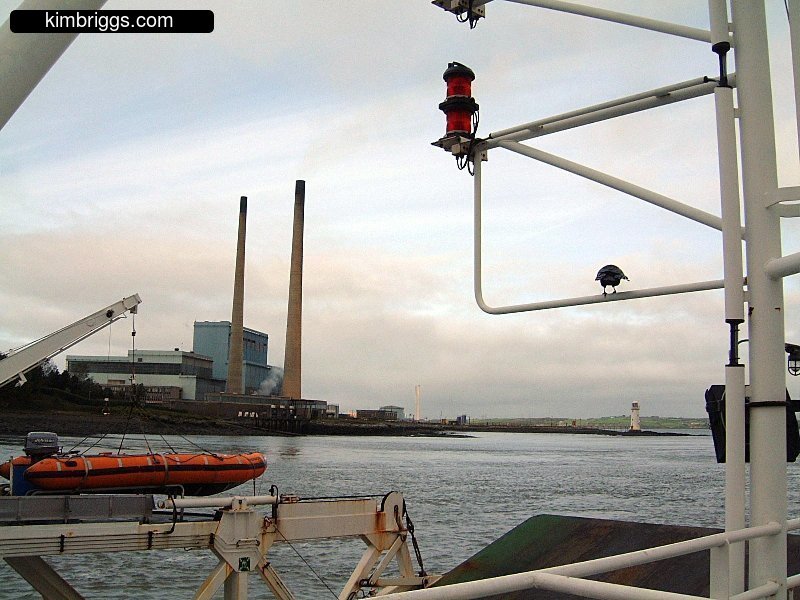 Smokestacks and plant near edge of a river.