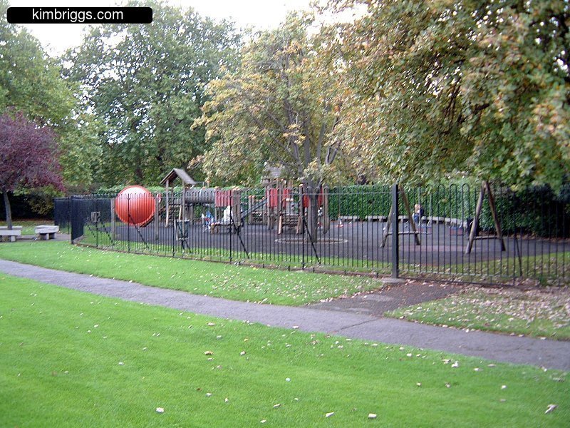 Fenced playground in green park.
