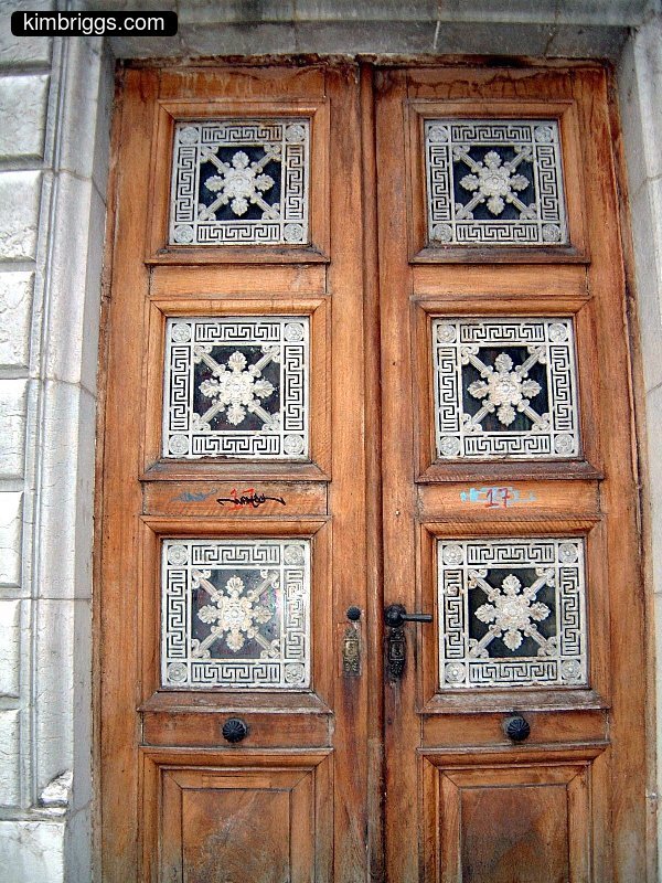 Old wooden doors with fancy windows.