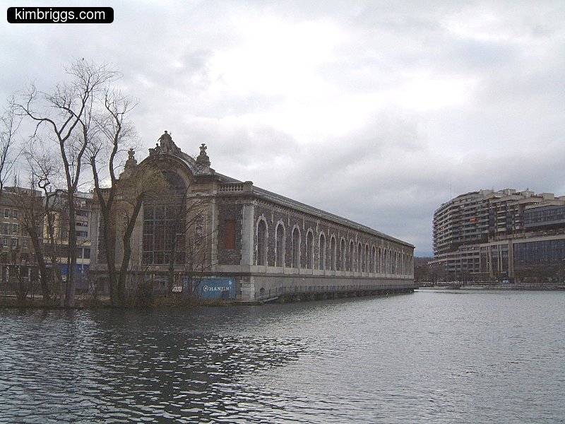 Long stone building with foundation in lake.