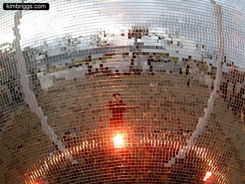 Close-up of mirror ball with light source.