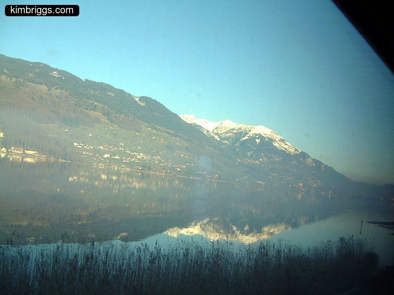 Mountain reflection in lake viewed from train.