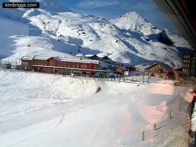 Women's reflections looking at train station in the snow.