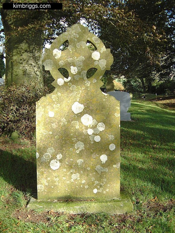 Large gravestone cross covered in moss.